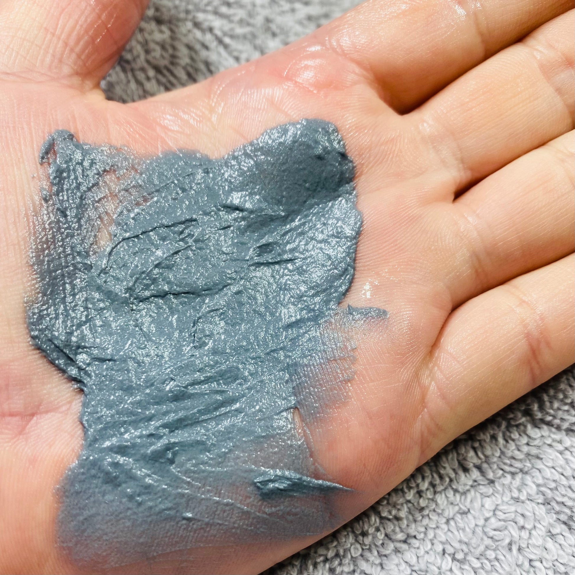 active clay cleanser spread on the palm of my hand