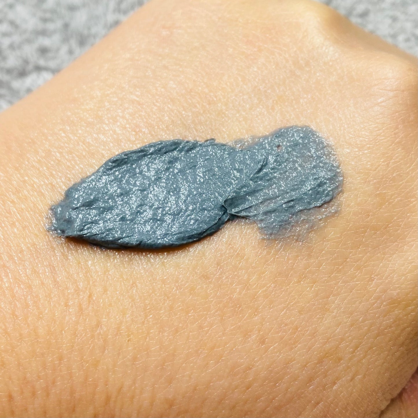 active clay cleanser spread on the back of hand