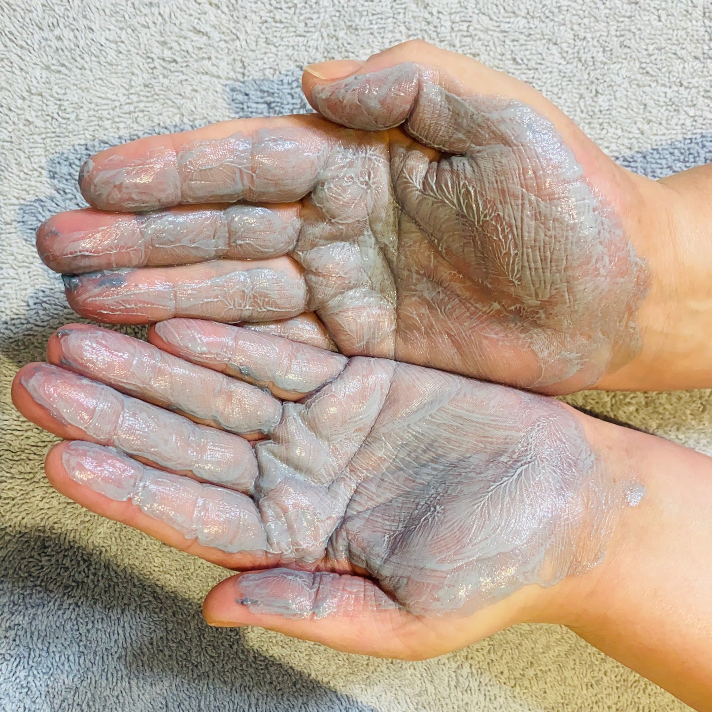 active clay cleanser spread over the palms of my hands